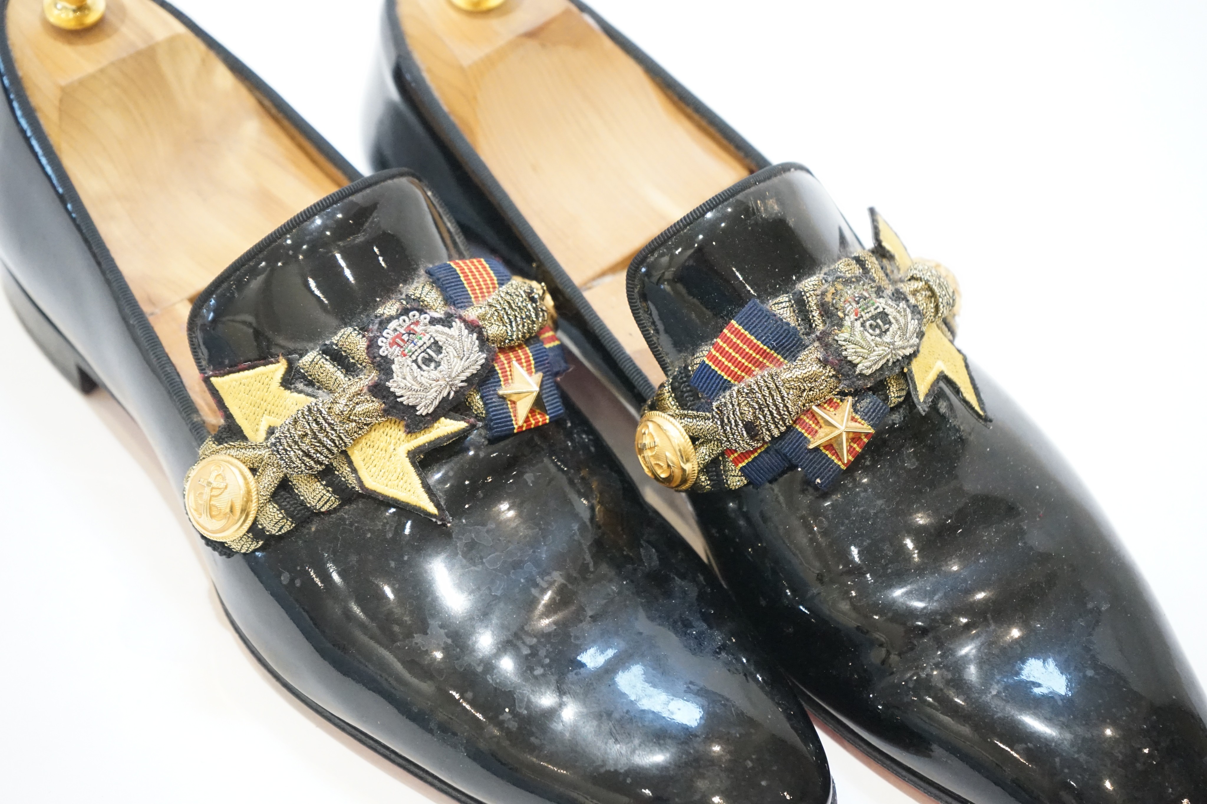 A pair of gentleman's Christian Louboutin patent leather dress shoes with applied and embroidered crests, size 43, in bag